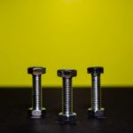 Three hex bolts on a yellow background