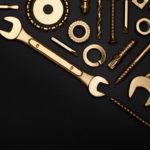 Brass wrenches and fittings on a black background